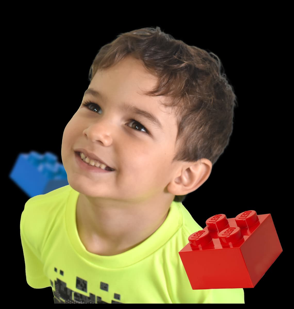 niño sonriendo mientras juega con legos